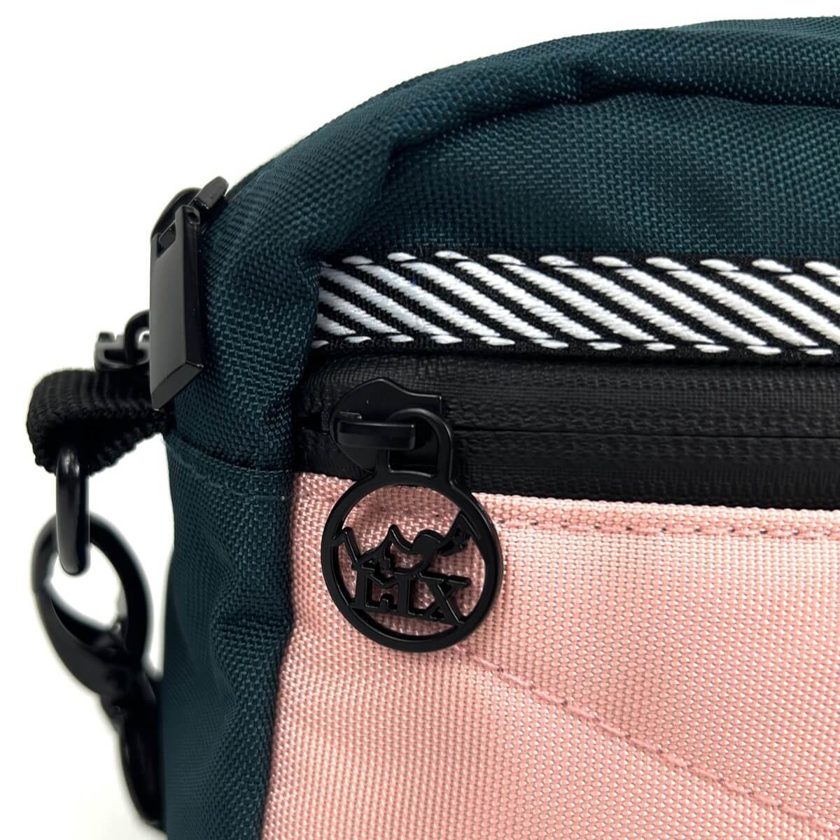 Sac bandoulière rose et vert conçu par Lix design une entreprise Québécoise. Languette de fermeture éclair avec logo de montagne et inscription LIX. Marque québécoise. Shoulder bag urban.