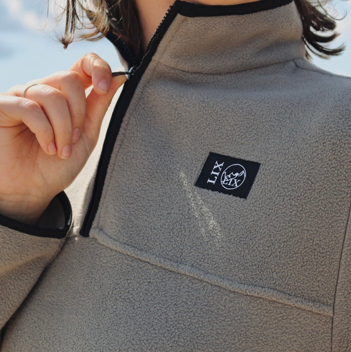 Chandail hoodie fait en polar de couleur taupe. Unisexe. Fleece taupe, gris, beige. 1/4 zip au devant. Bordure noir. Poches avec fermeture éclair.