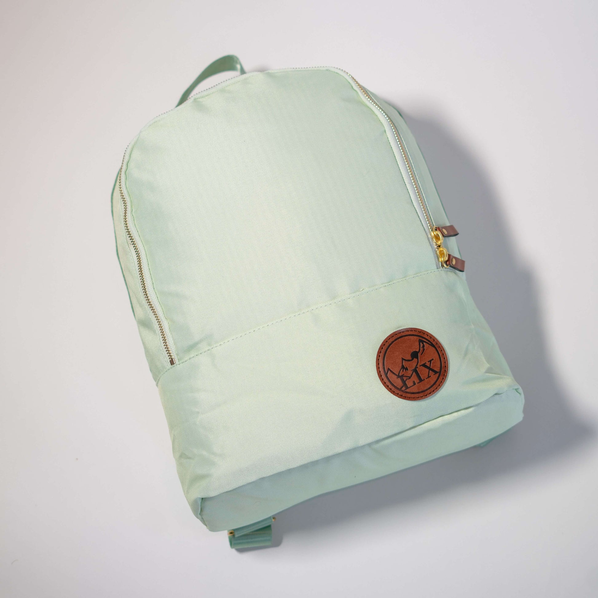 Sac à dos de couleur vert menthe. Poche caché à l'arrière pour contenir votre cellulaire. Sangles ajustables de couleur lilas. Pochette pour cellulaire caché au dos. Fait de bouteilles de plastique recyclées.  Backpack made in canada. Lix. Sac a dos Canada