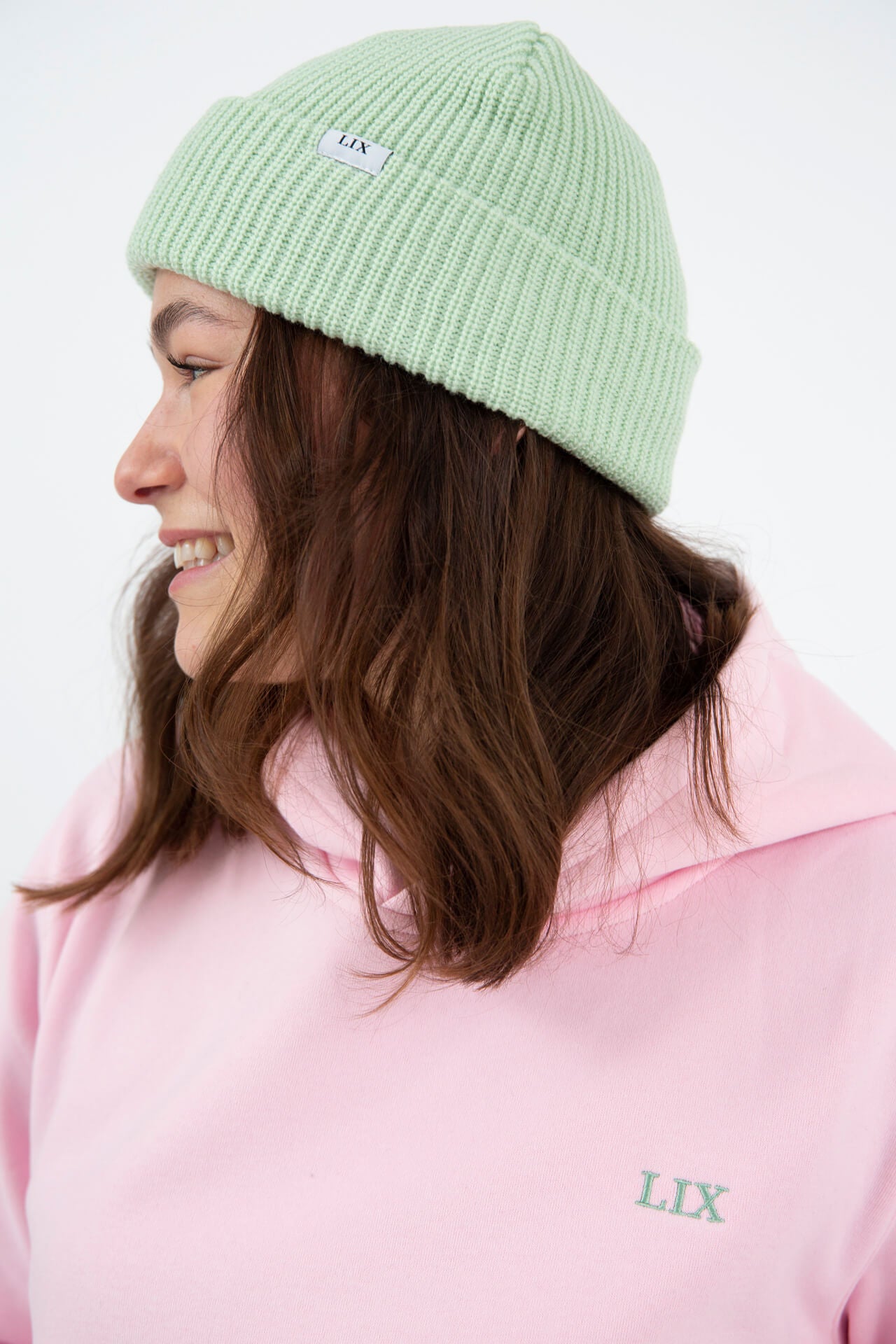 Tuque de style fisherman de couleur mingt.  Hoodie rose avec imprimé couleur vert.