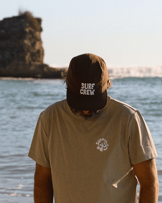Casquette brune avec protection des rayons u.v. avec broderie blanche en 3d inscription surf crew ajustable à l'arrière. concu par lix une entreprise québécoise.