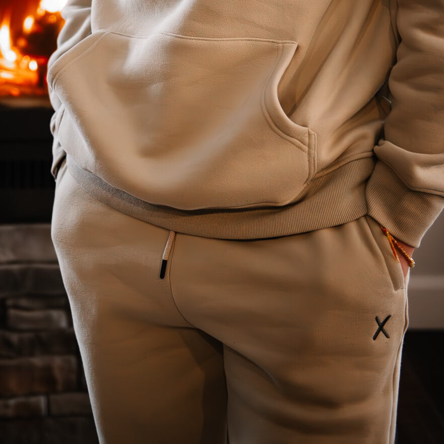 Pants jogger beige avec broderie grise foncé. unisexe chaud et confortable. Élastique à la taille avec cordon d'ajustement en plus pour un confort incomparable. Poches sur les côtés.