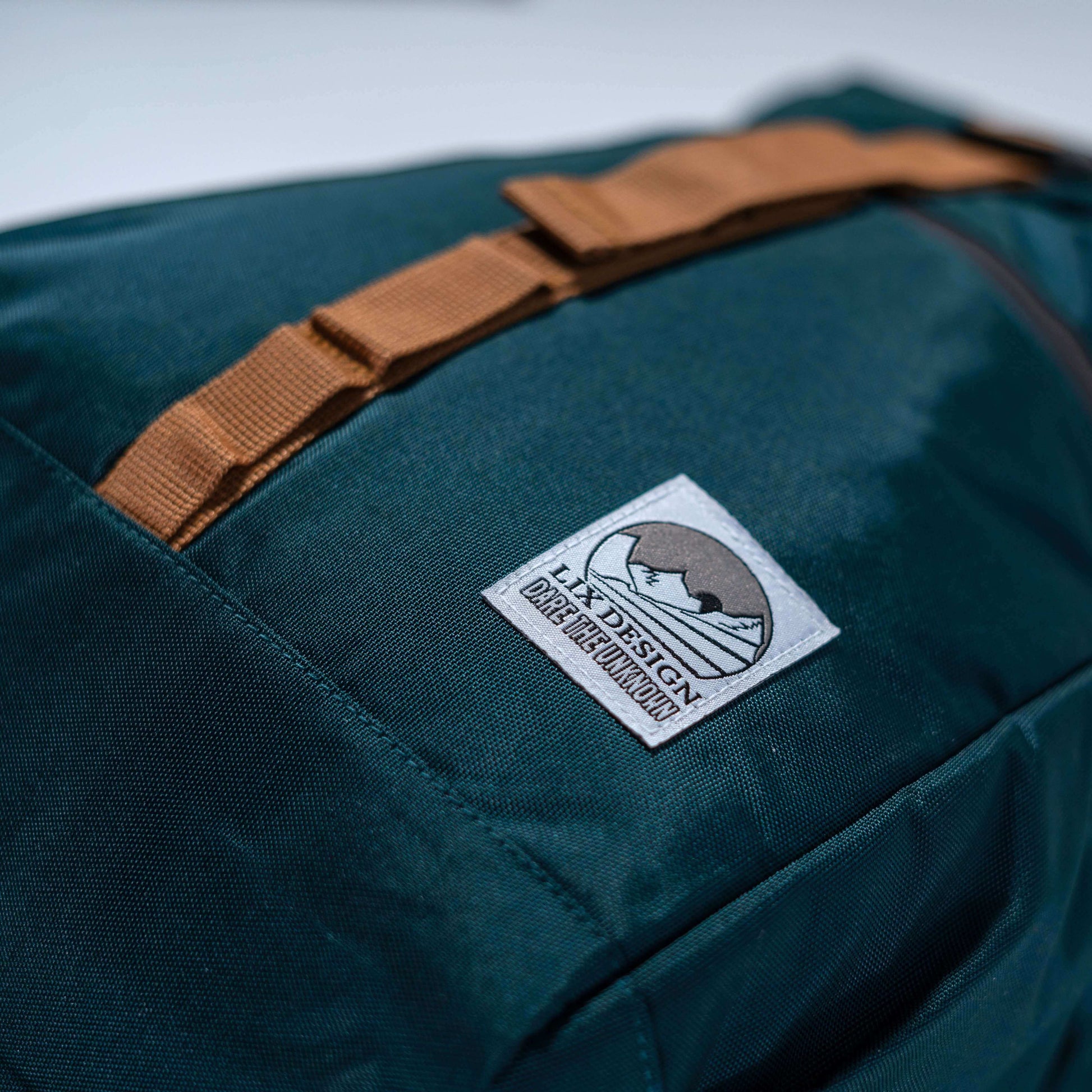 Sac à dos vert émeraude en polyester recyclé conçu par lix une entreprise Québécoise. Plusieurs pochettes et compartiments pratiques. Ganses de transport rembourrées. Backpack made in canada. Lix. Sac a dos Canada