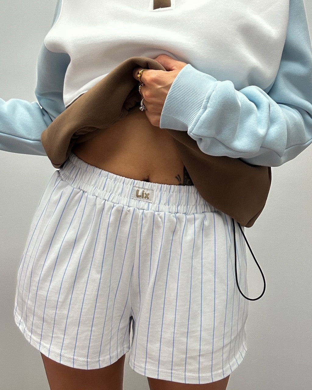 Short blanche avec rayure bleu. Poches et élastique confortable. Conçu par lix pour les femmes du Québec.