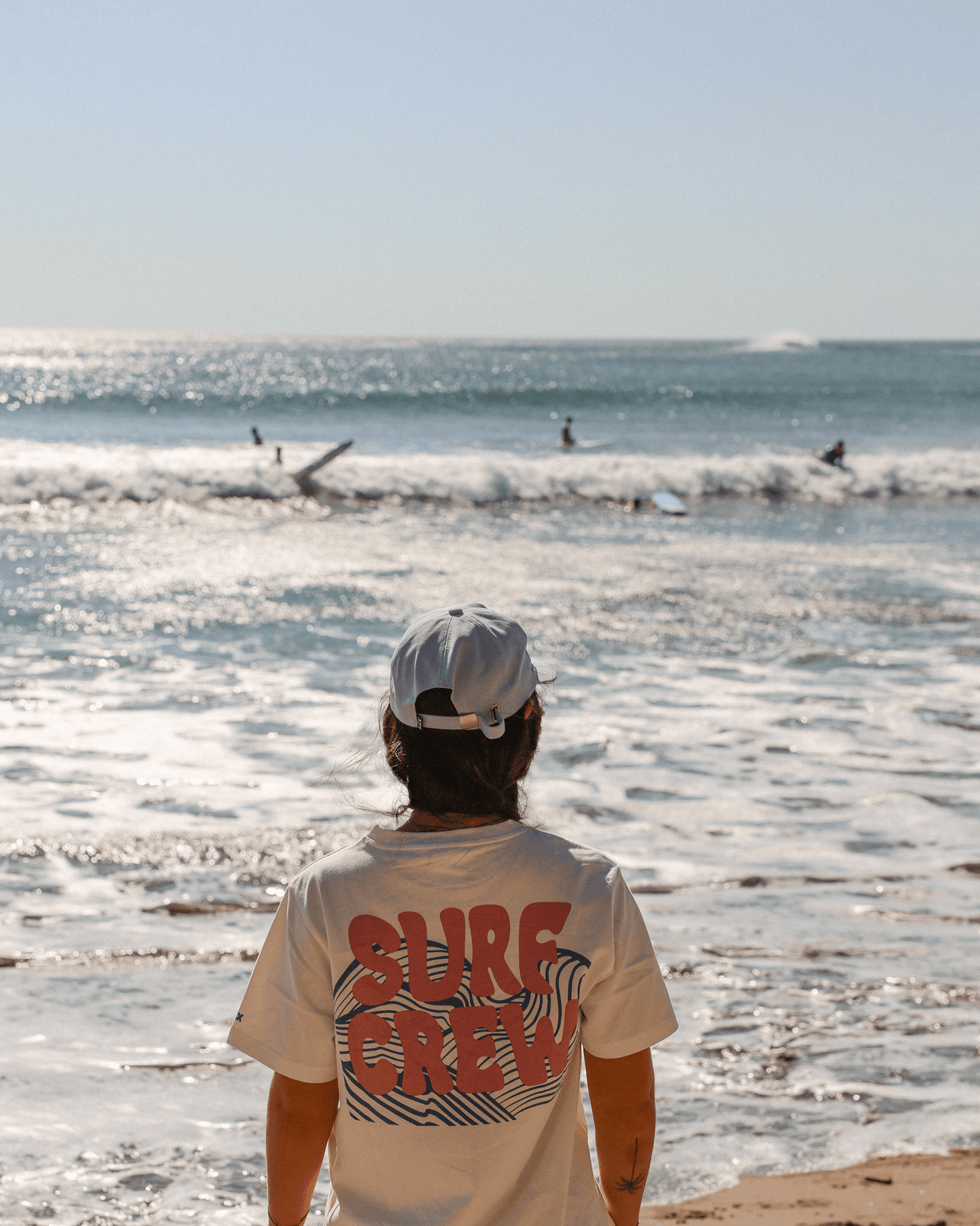 Tshirt blanc avec imprimé surf crew rose au dos. Concu par lix une entreprise québécoise.