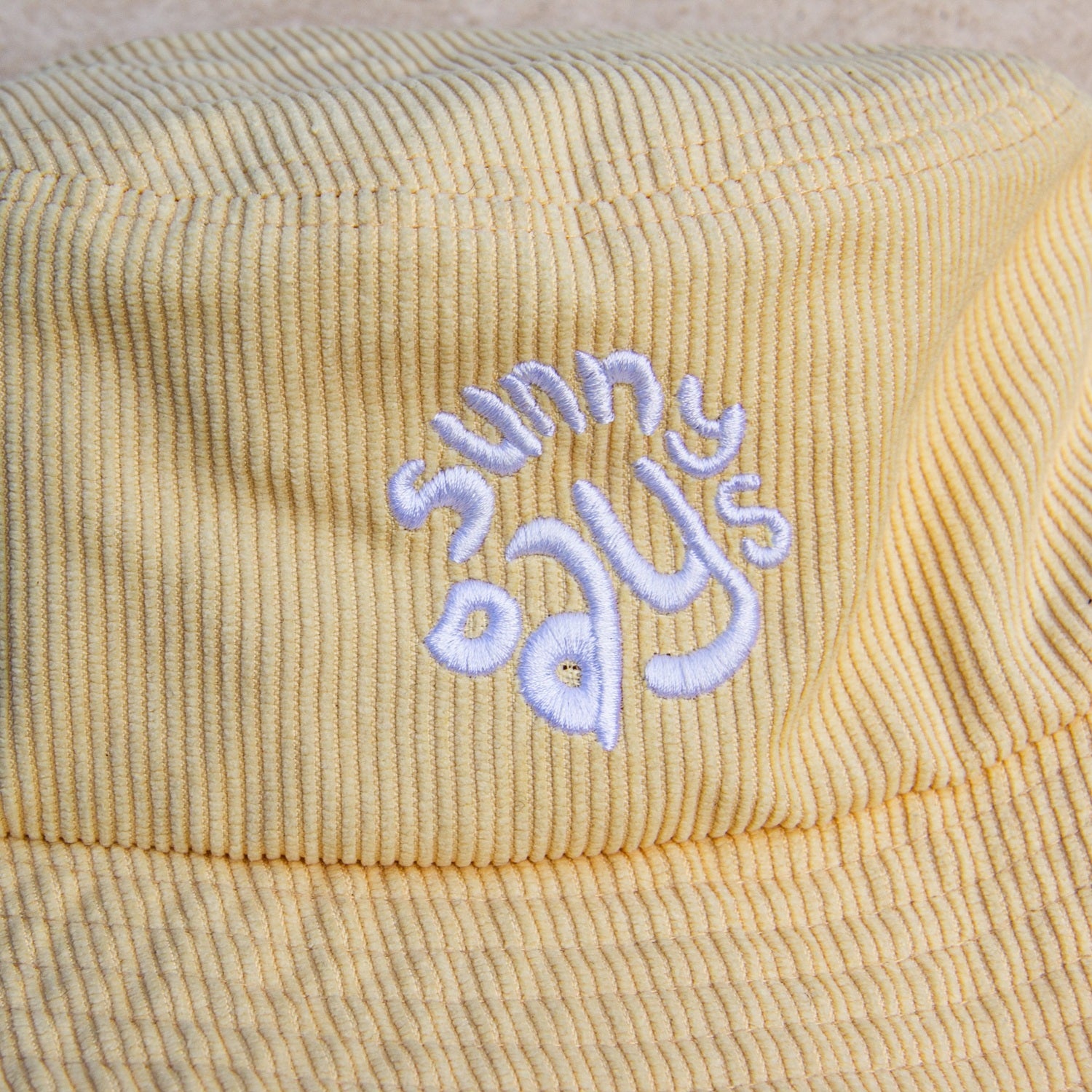 Chapeau corduroy jaune avec broderie sunny days en blanc.