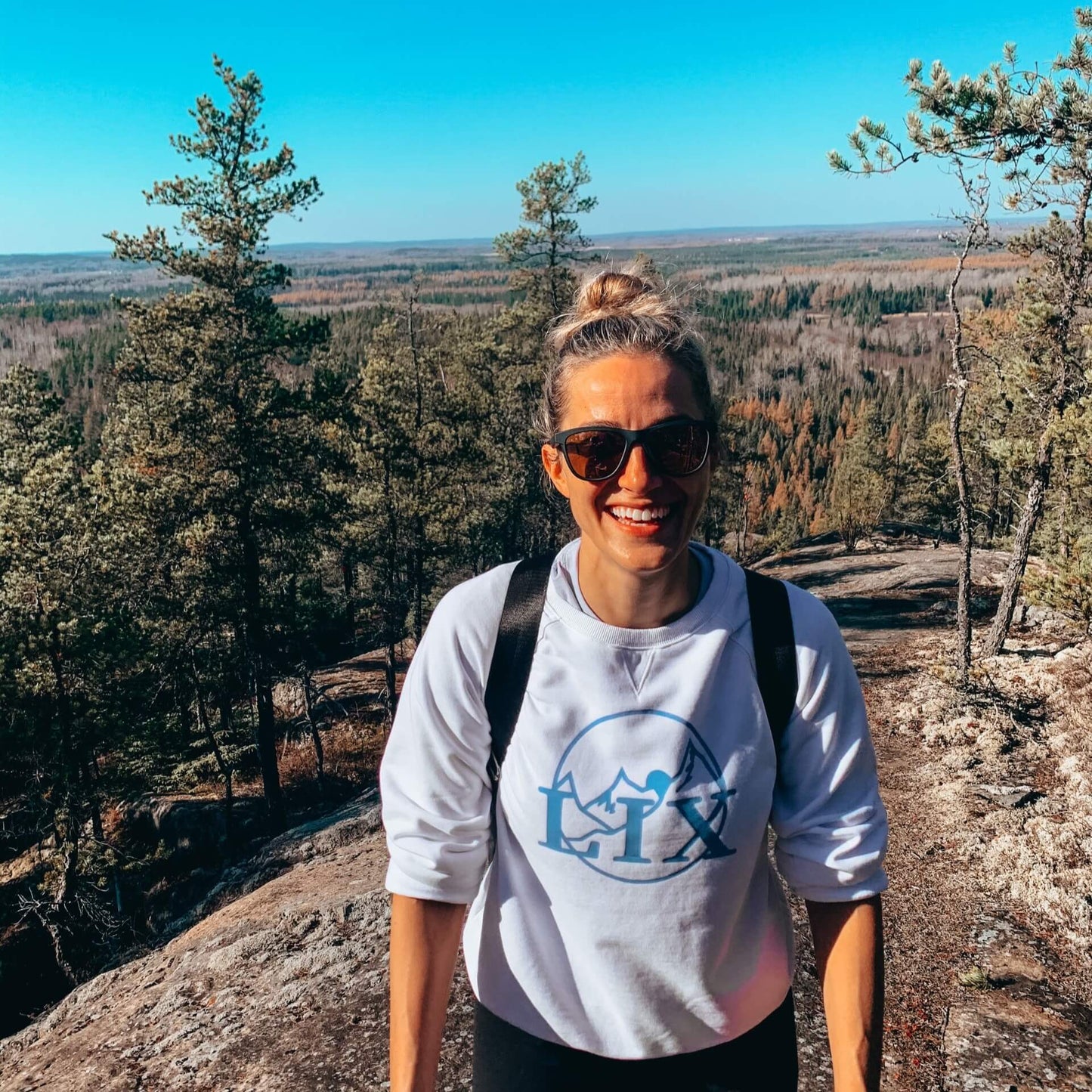Chandail blanc avec logo en bleu au devant, pour femme conçu par Lix design une entreprise québécoise.