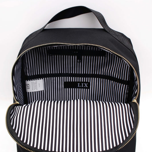 Sac à dos école ou sac à main noir avec int6érieur rayé noir et blanc. Fermeture éclair de couleur or. Grandeur poche intérieur. Grandeur 16L. Pochette intérieur pour ordinateur. Petite poche extérieur pour cellulaire. Badge en cuir synthétique végan. Fait de polyester recyclé à partir de bouteilles de plastique recyclées. Créé par Lix design une entreprise québécoise. Backpack made in canada. Lix. Sac a dos Canada