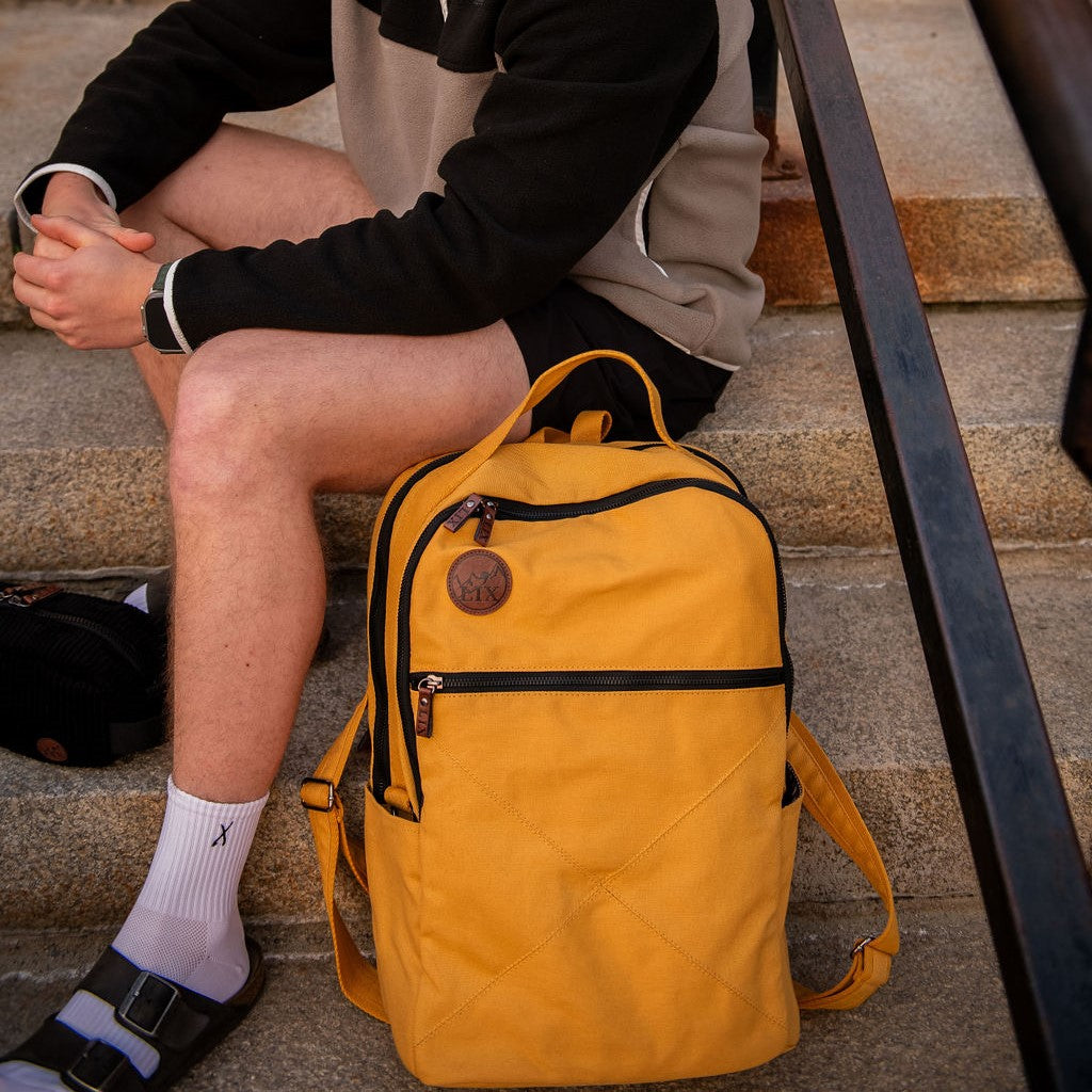 Sac à dos en polyester recyclé. Conçu au Québec. Unisexe. De couleur jaune ocre. Plusieurs poches pratique. Végan et écoresponsable. Backpack made in canada. Lix. Sac a dos Canada. Backpack made in canada. Lix. Sac a dos Canada
