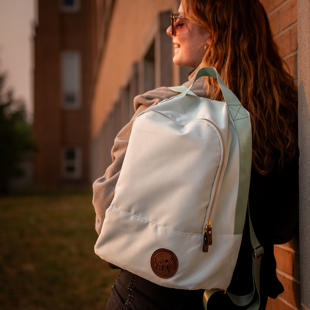 Sac à dos vert menthe, mint fait de bouteilles de plastique recyclés par une entreprise québécoise, Lix design. Badge en cuir végan synthétique.  Backpack made in canada. Lix. Sac a dos Canada
