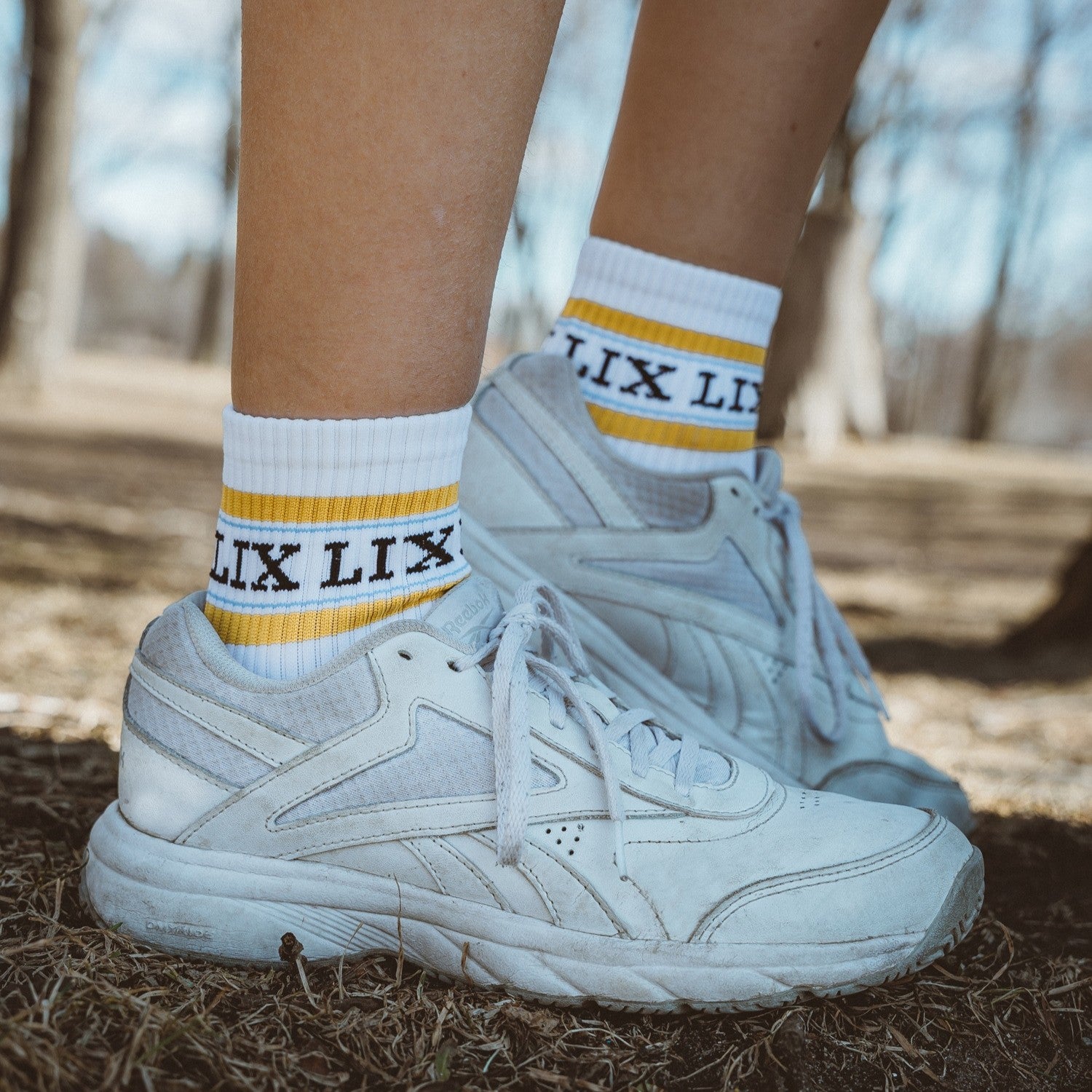 Bas blanc avec rayure jaune, lix en noir. Chaussette blanche et jaune. Bas court.
