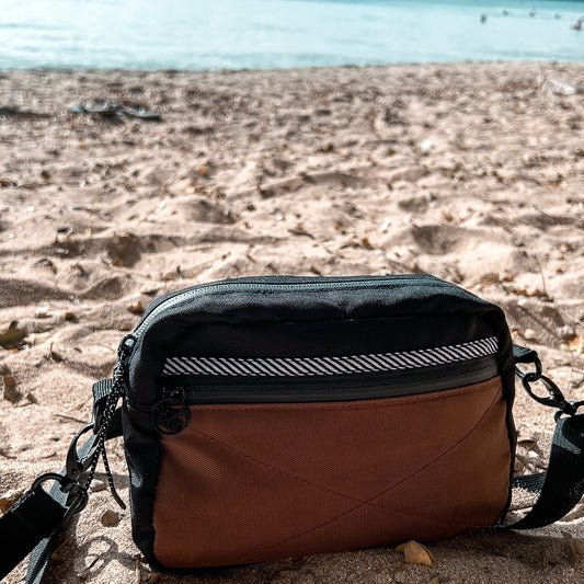 Pochette bandoulière de couleur noir et brune conçu par Lix une entreprise Québécoise.