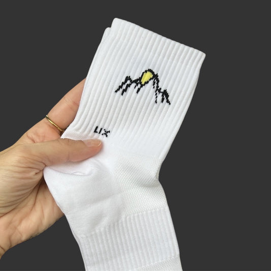 Bas en nylon de couleur blanc avec imprimé montagne et soleil conçu par Lix une entreprise Québécoise. Bas court.