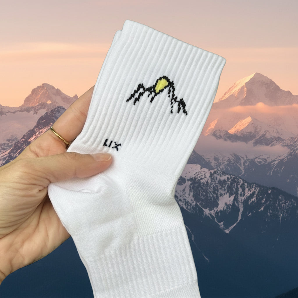 Bas en nylon de couleur blanc avec imprimé montagne et soleil conçu par Lix une entreprise Québécoise. Bas court.