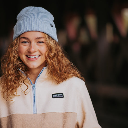 Polar fleece de couleur beige avec bordure bleu. Poches avec fermeture éclair. Coton ouaté de couleur beige avec bordure bleu pâle. tuque bleu fisherman bleu pudre