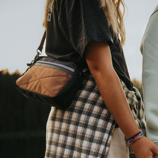 Sac bandoulière de couleur noir et brun avec bande rayé noir et blanc. Conçu par Lix design une entreprise Québécoise. Réversible et unisexe.