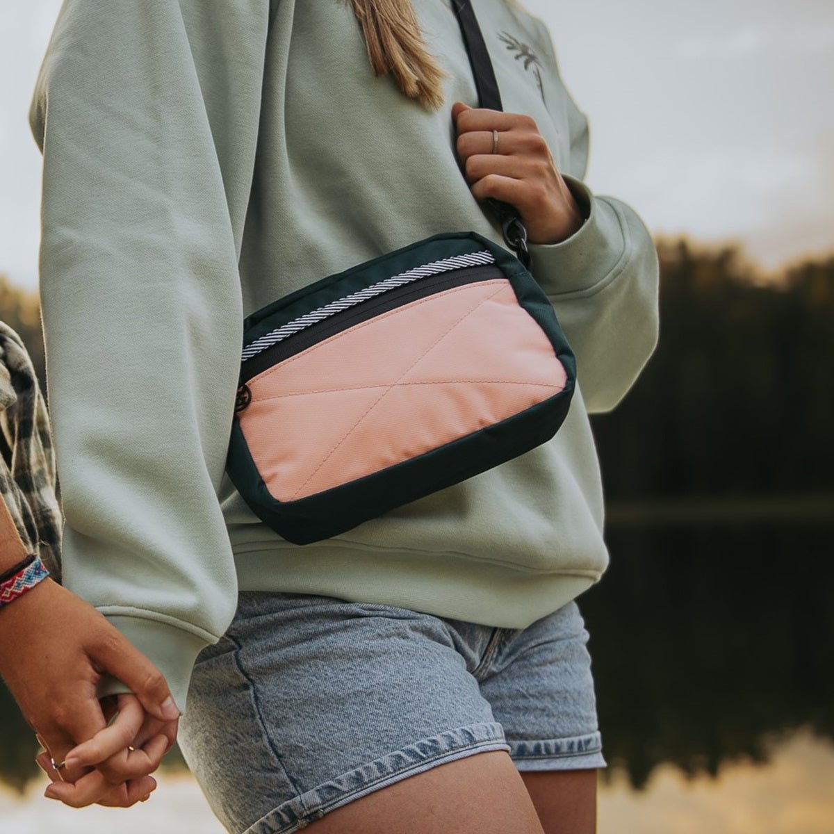 Sac bandoulière de couleur vert et rose conçu par Lix design une entreprise Québécoise. Fait de matières recyclées. Réversible et unisexe.