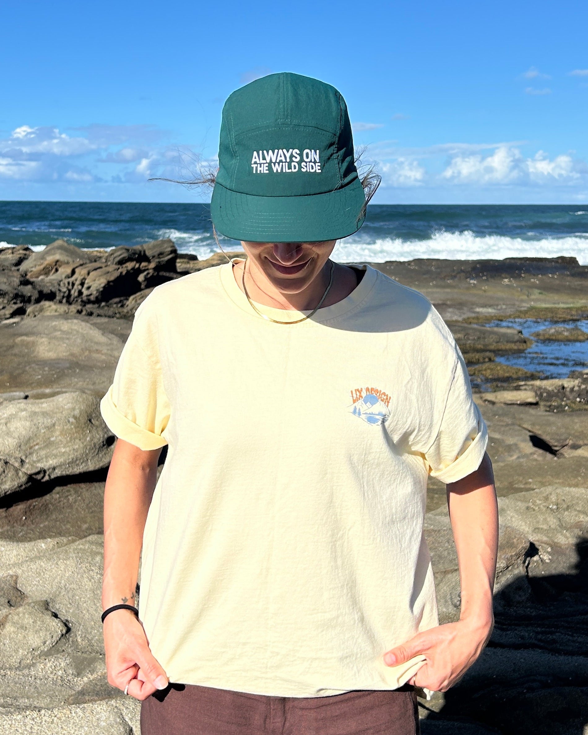 Casquette verte avec protection u.v. pour homme et pour femme. Conçu par lix une entreprise québécoise. Tshirt beige avec imprimé. 