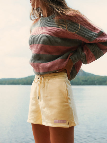 Tricot Classic Stripe rose LIX Design – Porté avec short jaune, look lifestyle.