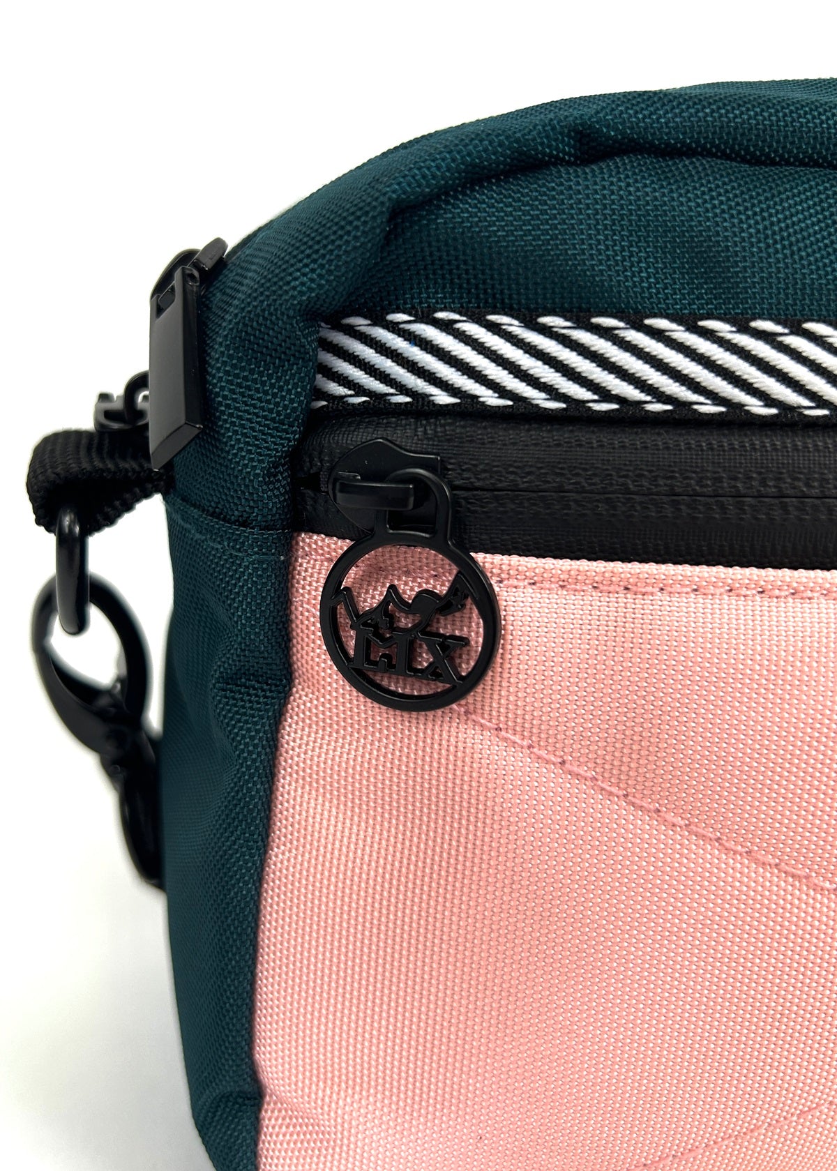 Sac bandoulière rose et vert conçu par Lix design une entreprise Québécoise. Languette de fermeture éclair avec logo de montagne et inscription LIX. 