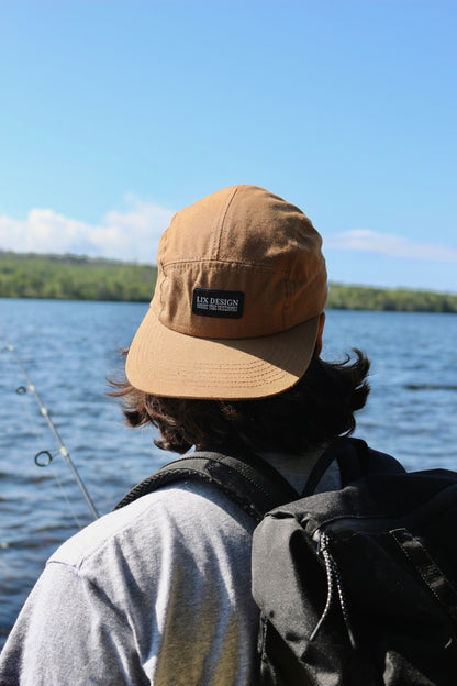 Casquette écoresponsable conçu par Lix design une entreprise Québécoise. Unisexe et fait de matières recyclées pour les plus écolos. Casquette de couleur brune avec étiquette noir. 5 pannels. Chapeau de pêche.