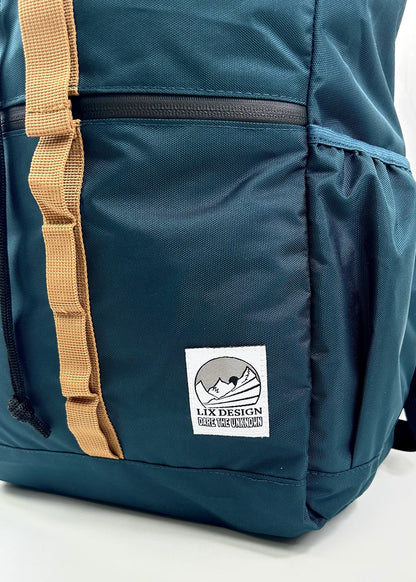 Sac à dos 26 litres conçu par Lix design une entreprise Québécoise. Étiquette tissé blanche avec logo de montagne noir. Attache de couleur brune et sac de couleur émeraude bleu vert.  Sac à dos Lavoir. Sac d'école. Sac de camping. Sac north Face. Sac de voyage. 