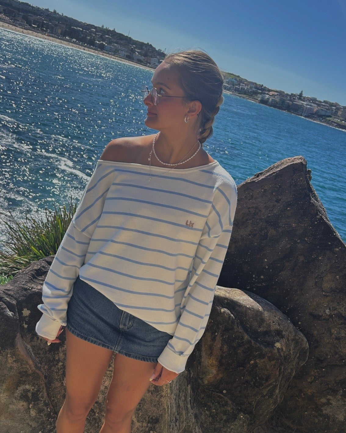 Pull rayé blanc et bleu avec vision mer. 