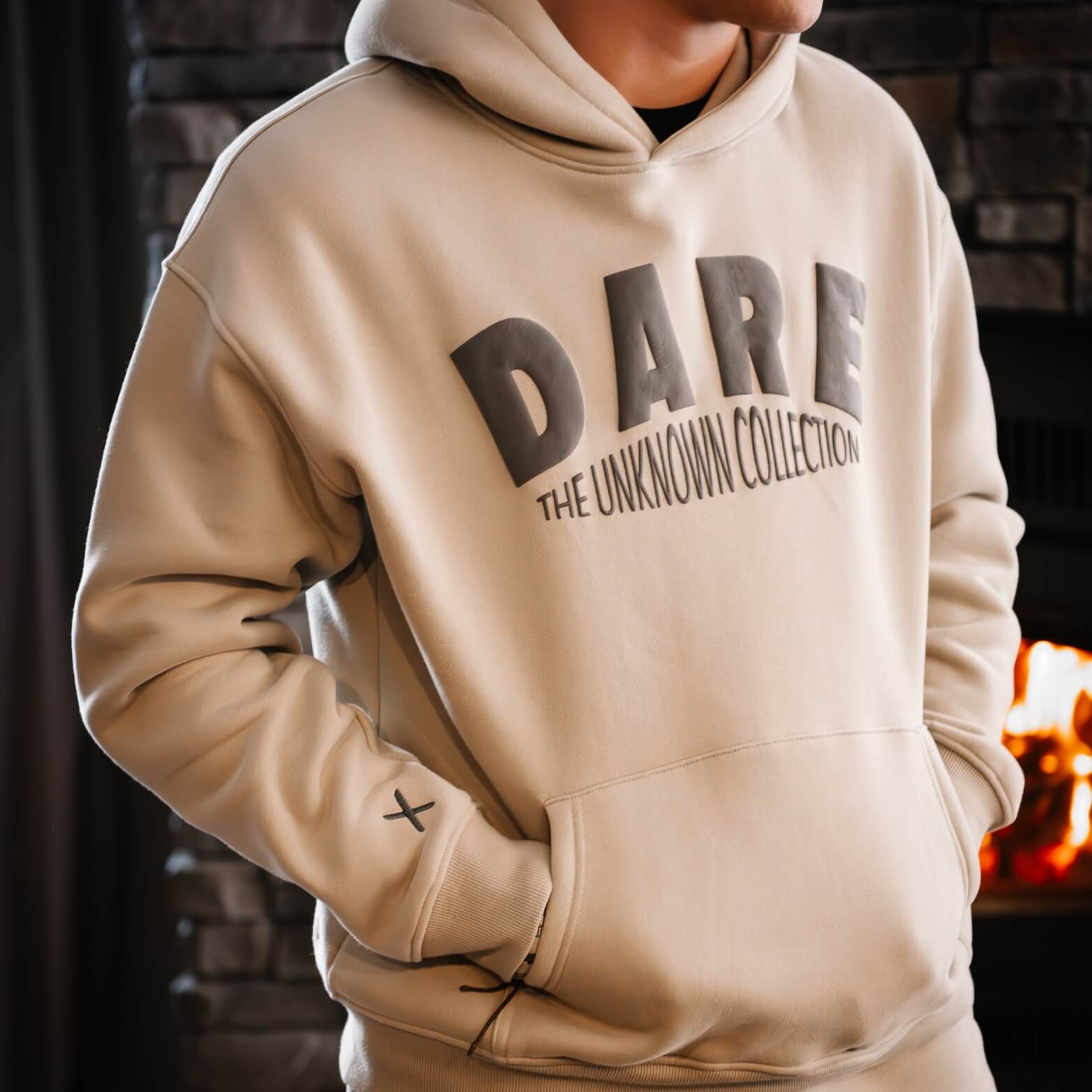 Hoodie Dare en 3D beige et lettrage gris foncé. Chandail à capuche chaud et confortable. Unisexe. Grandeur standard homme. 