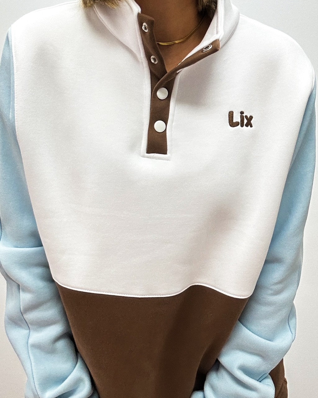 Chandail neutre blanc bleu brun. Broderie minimaliste brune lix. Bouton pression au devant. ajustable à la taille. Pour femme. 