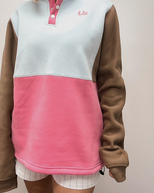 Crewneck rose bleu et brun ajustable à la taille. Bouton pression au col. Conçu au Québec pour les femmes de 25-45 ans qui voyagent. 