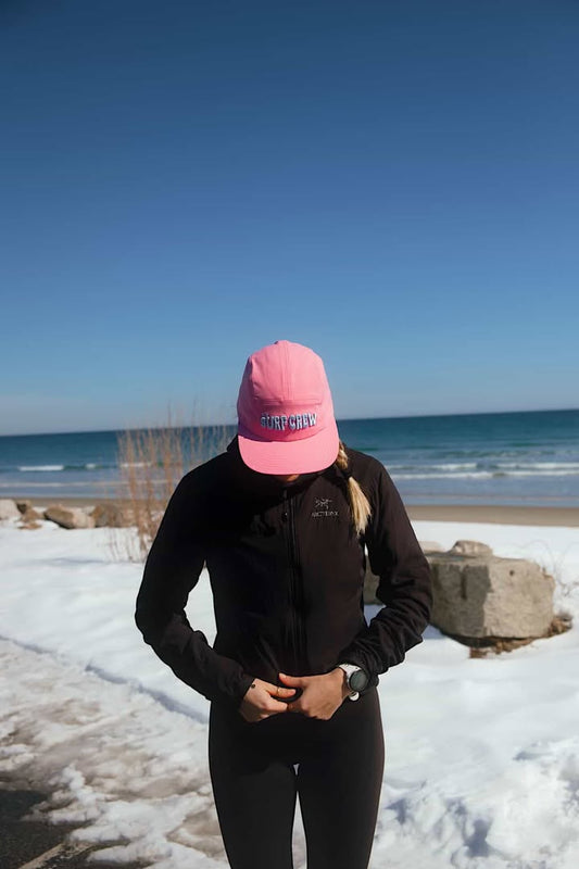 Casquette rose avec protection uv. Grosse broderie surf crew bleu au devant. Ajustement avec une sangle à l'arrière. 