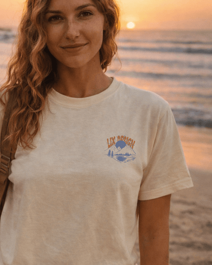 T-shirt beige avec imprimé au devant coté cœur lix design montagne bleu avec soleil levant. 