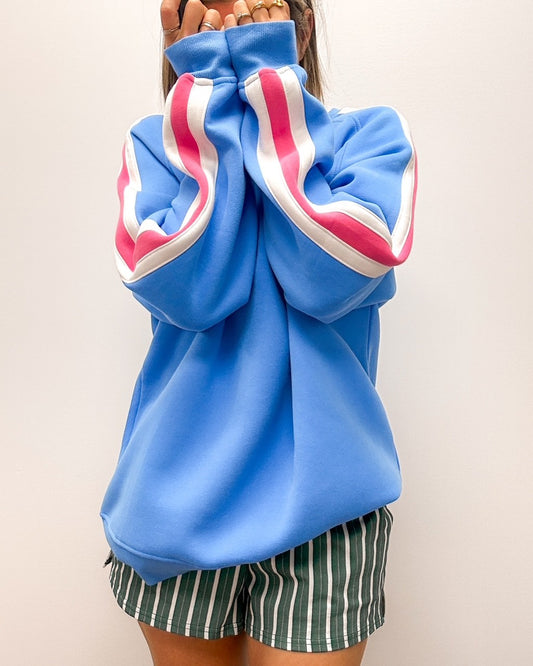 Crewneck chandail bleu avec rayure rose et blanche sur les manches. Broderie minimaliste rose au devant. Manches raglan en coton. confortable et oversize. Concu par lix  une entreprise québécoise. 