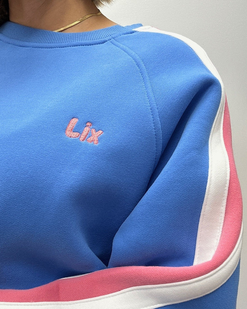 Crewneck bleu avec broderie lix rose et un style des années 90. Conçu au Québec pour les hommes et femmes. 