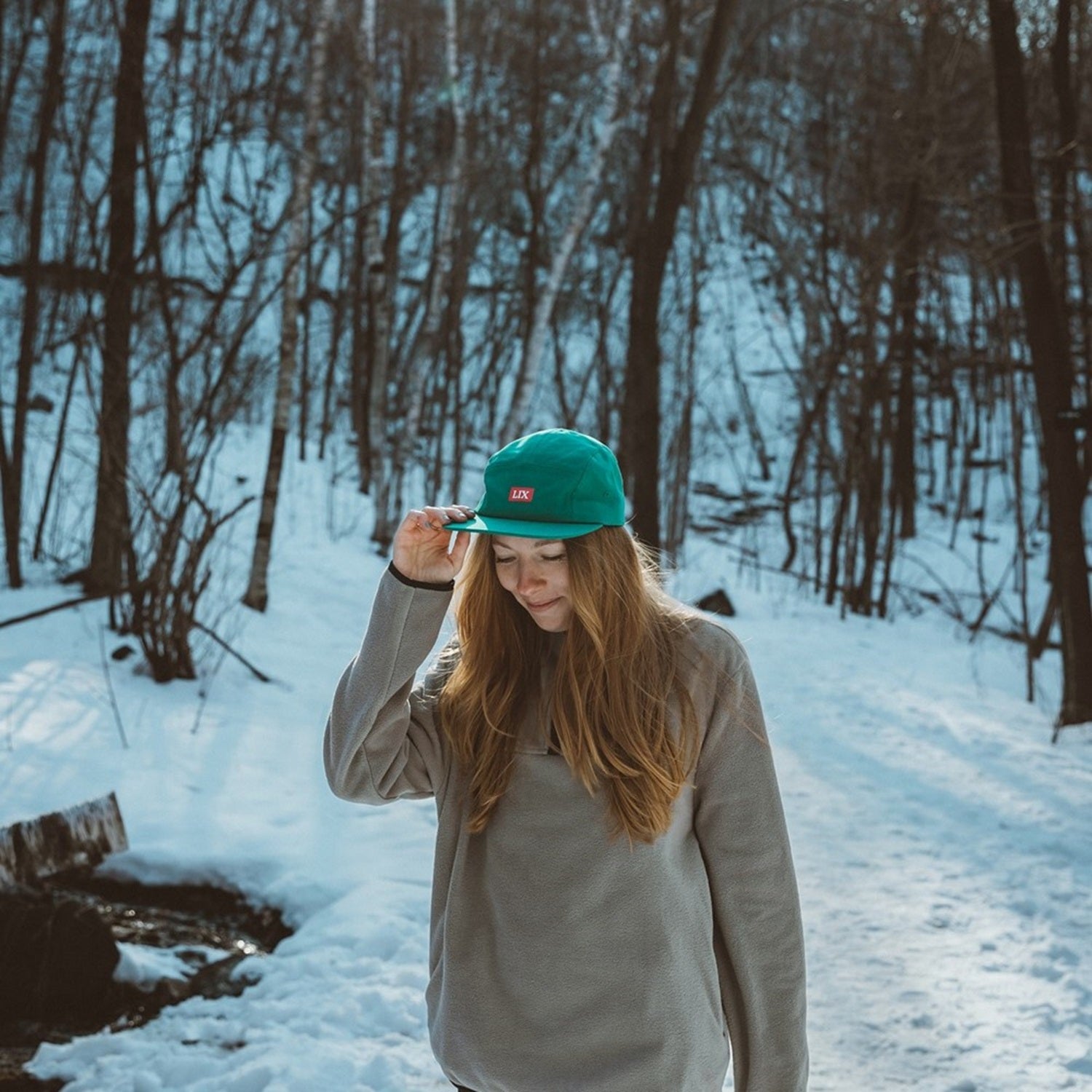 Casquette conçu par Lix design une entreprise québécoise. Fait de polyester recyclé à partir de bouteilles de plastique récupérées. De couleur verte avec logo en rose.