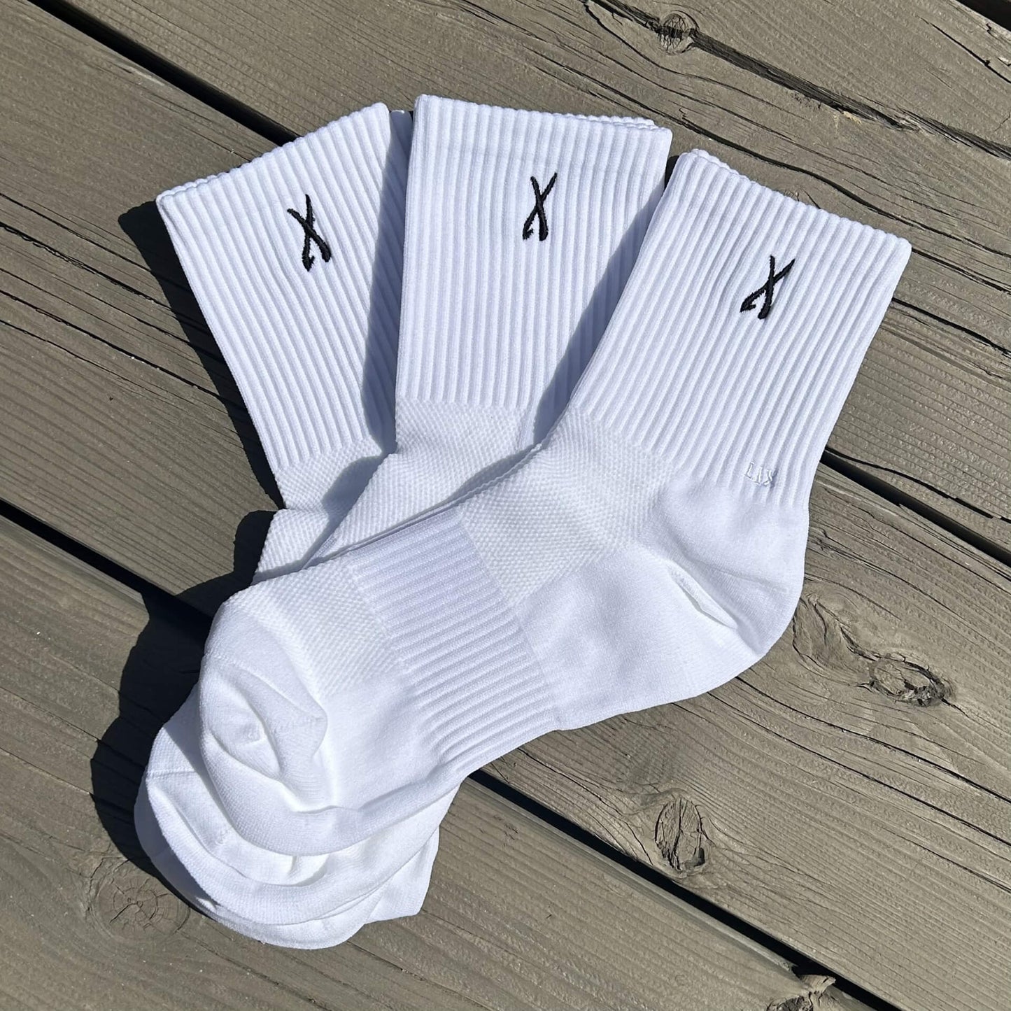 Trio de bas blanc pour les sports avec broderie noir d'un X. Chaussette blanche pour les sports. 